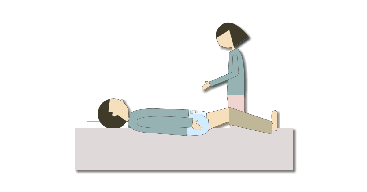 ズボンを脱がずにテープ型紙おむつを交換する様子
